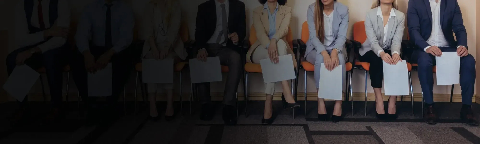 Group of people sitting on chairs waiting to be interviewed by interviewer