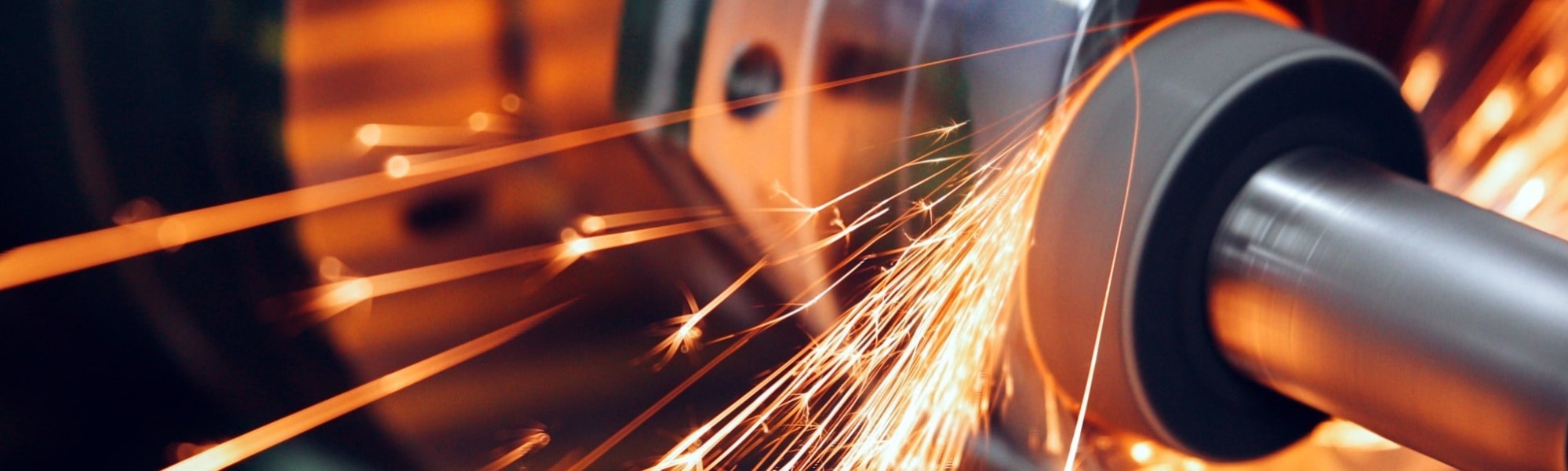 sparks flying while machine grinding and finishing metal in factory, manufacturing, engineering