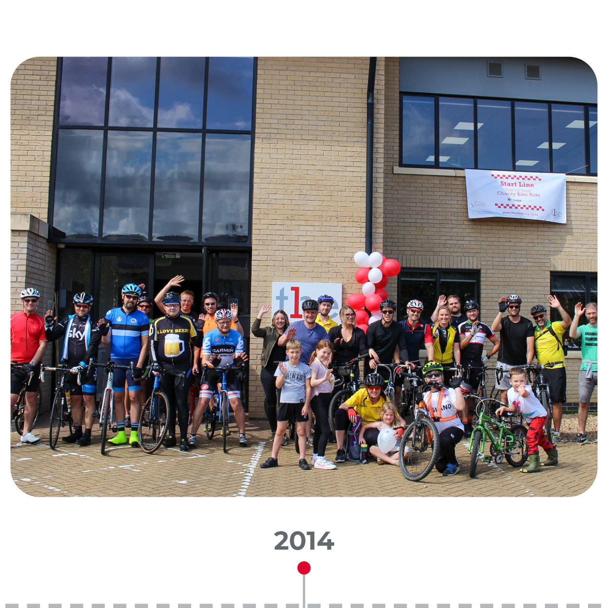 The ONE Group's employees smiling outside the office ready for a charity bike ride.