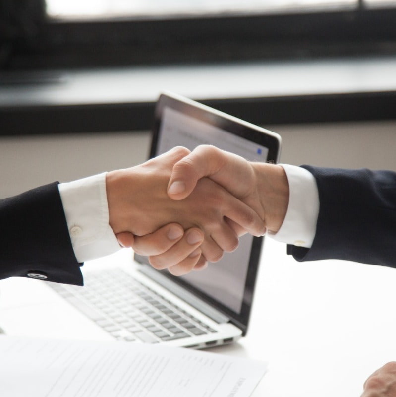 Two people shaking hands to close a deal