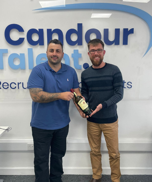 Candour Talent Recruitment Agency - Candidate Page. Picture of Managing Director Matthew Burkitt presenting a gift to our Senior Sales Consultant Scott Smith, accompanied by the caption: 'At Candour Talent, we empathize with the challenges of navigating the job market. That's why we prioritize understanding your unique needs and aspirations. Whether you're seeking temporary opportunities, a long-term career path, or simply seeking career guidance, our approachable recruitment consultants are here to assist you every step of the way