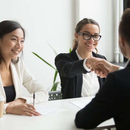 Businessman Shaking Hand Female Coworker During Company Meeting Min
