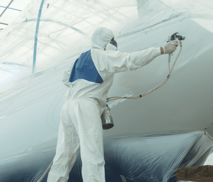 mobile image of worker applying boat coating and finishing
