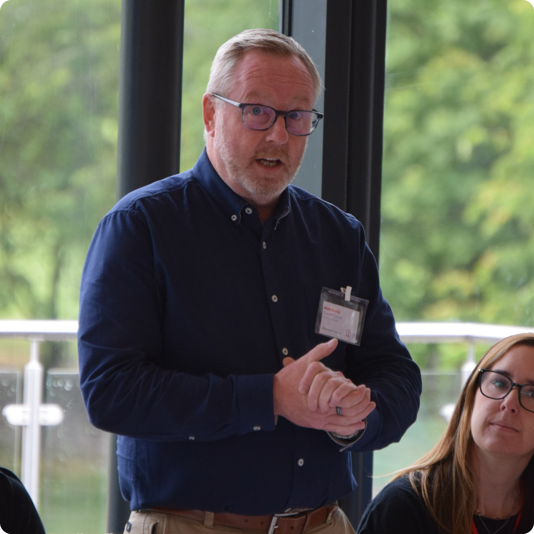 Man talking to an audience at an event.