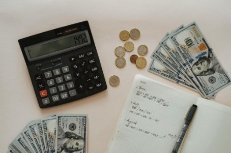 Calculator, money and notebook with calculations