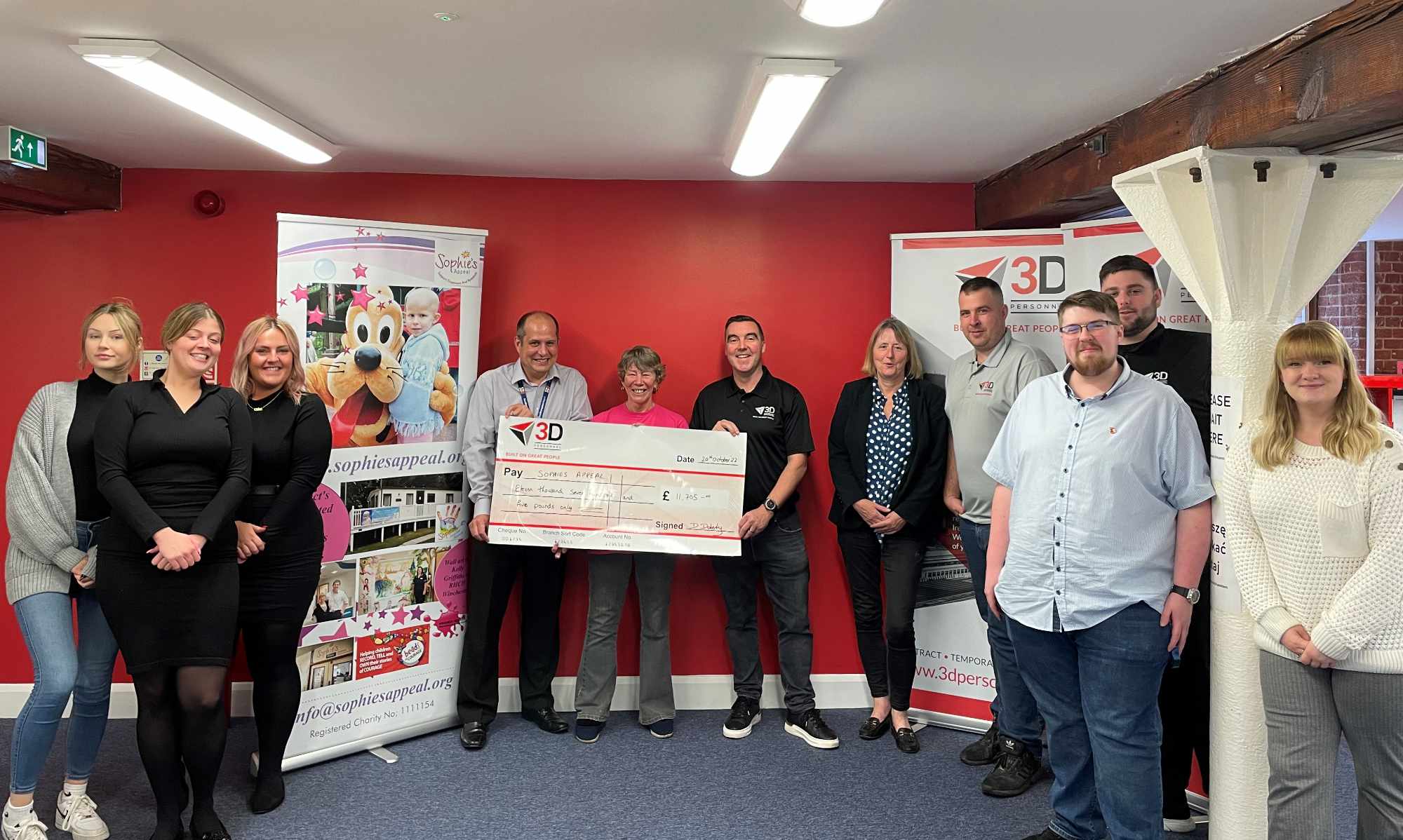 3D's Managing Director, Damian Doherty, presents a cheque for £11,705 to Lin and Mike Barringer in  2022, while the Southampton office staff look on 