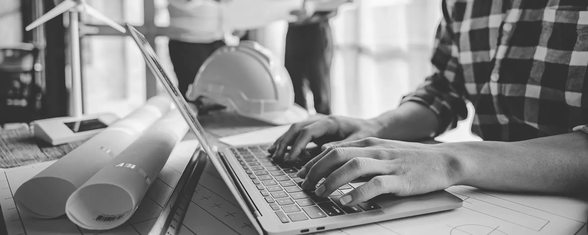 Construction worker typing on laptop
