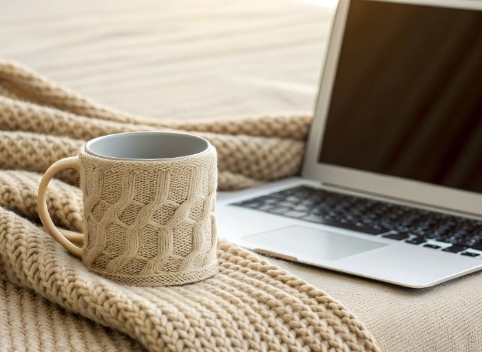 cosy blanket and mug infront of open laptop