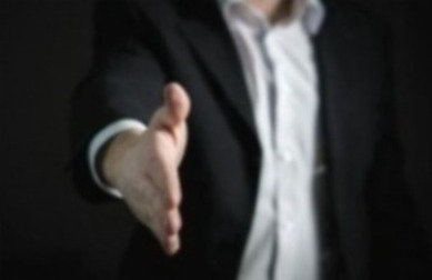 Individual in a suit with hand out 