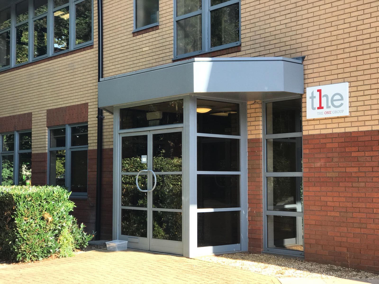 The ONE Group Northampton office building with a glass entrance and the company logo above the door.