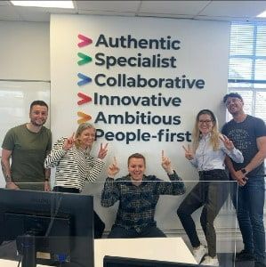 Jake Thomas, Adrienn Prezenszki, Aaron Stone, Claire Hales and Ollie Gearing of Next Phase Recruitment in Horsham are posing in front of our company values