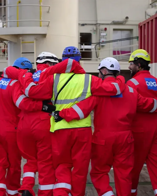 A group of offshore workers huddled as a team.