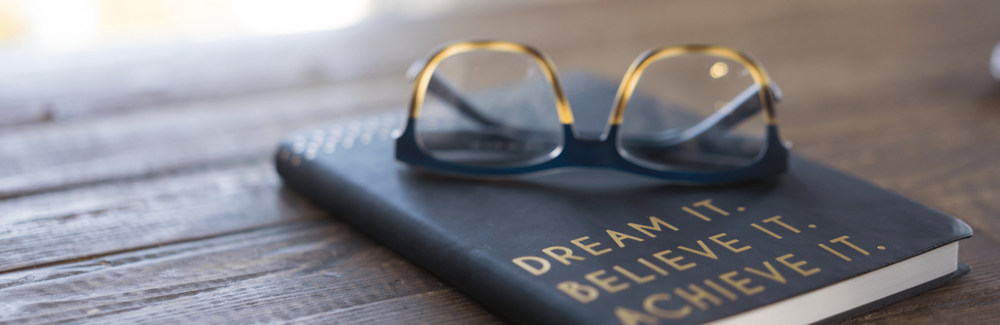 Motivational graphic displaying the words "dream it, believe it, achieve it" with a vibrant background.