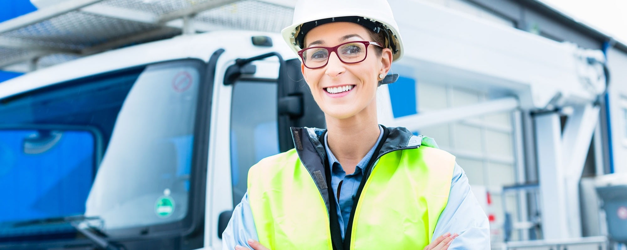 lady driver with hi vis jacket on infront of lorry van crane cherry picker smiling 