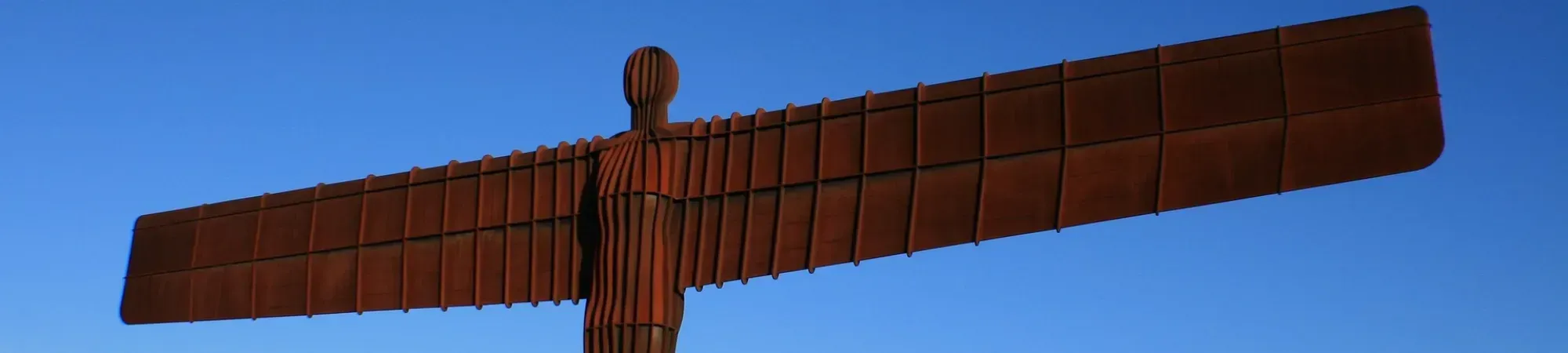 The Angel of the North, a large steel sculpture, stands tall in Newcastle upon Tyne, England, with wings spread wide.