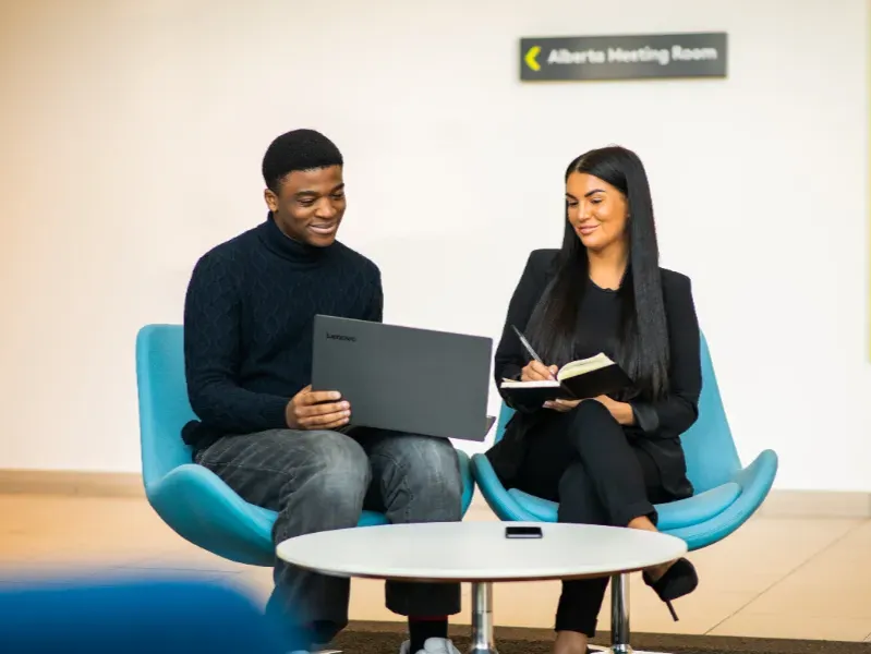 two people smiling over laptop