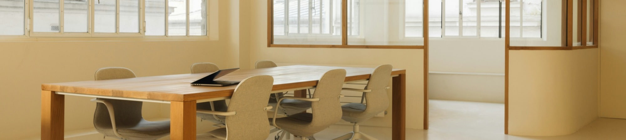 A wooden table surrounded by four chairs in a well-lit dining area.