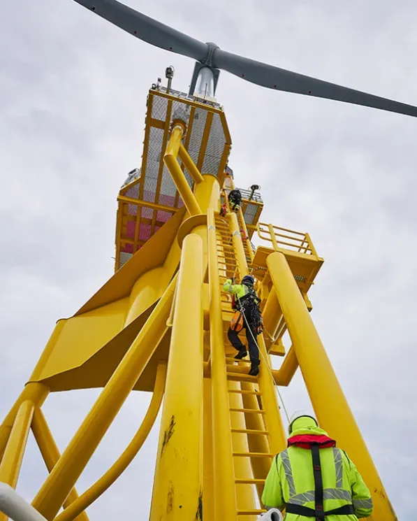 Offshore workers climbing an offshore wind turbine.