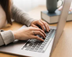 Hands typing on laptop keyboard