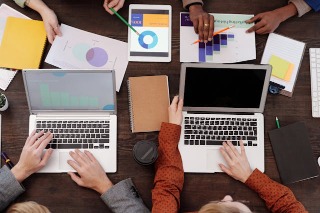 People working on laptops on a desk