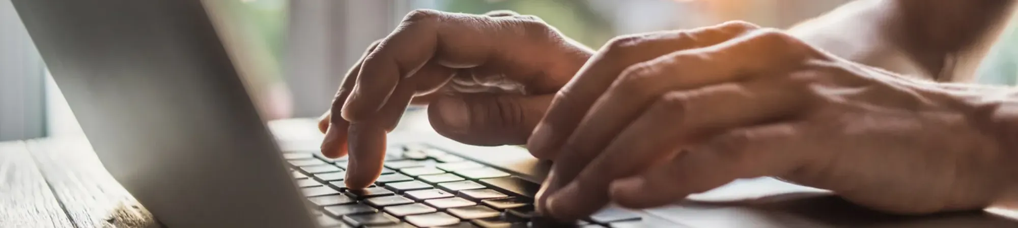 hands typing on a laptop keyboard