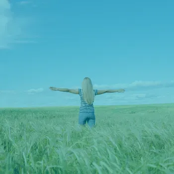 Woman standing in a field with her arms out