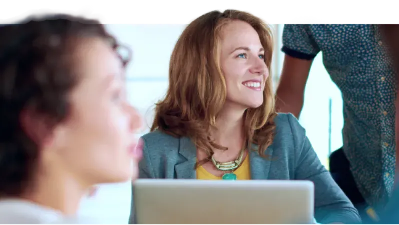 Smiling woman with her colleagues in the office 