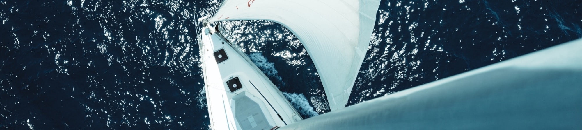 A boat owner and insurance agent engage in a deep discussion by the marina, surrounded by boats under the warm afternoon sun