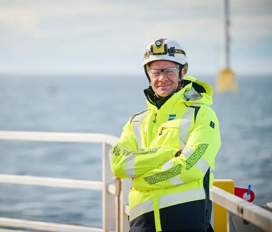 Offshore wind engineer standing with arms folded.