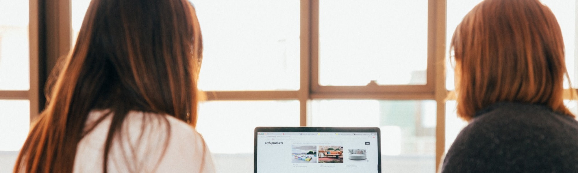 Two finance professionals collaborating on a project, focused on a laptop screen.