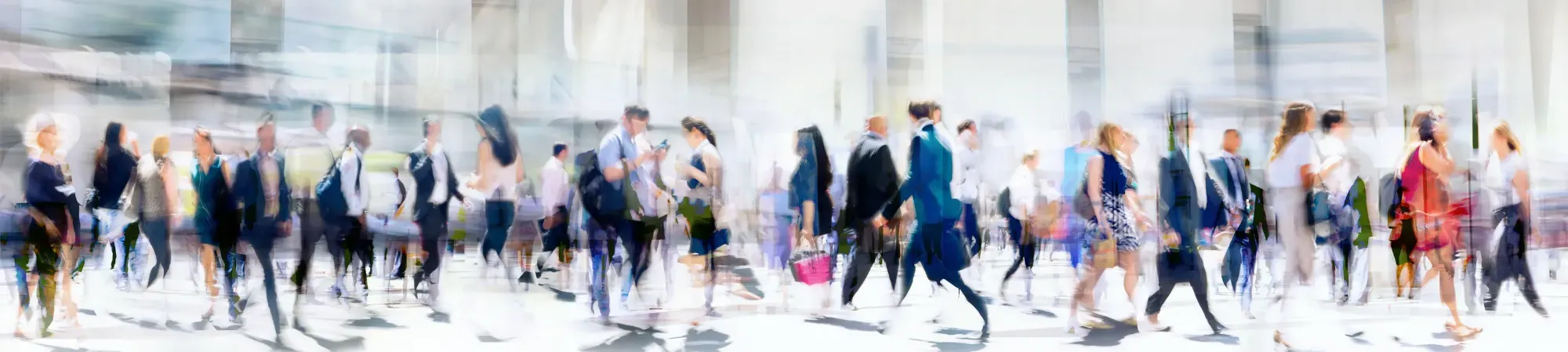 a vague image of many people walking with their phones in their hand, on their way to work.