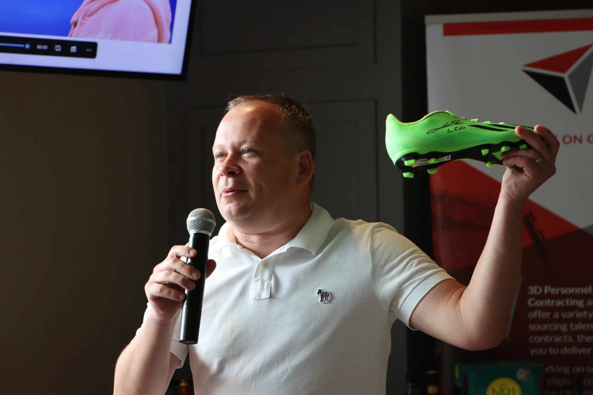 Our Auctioneer for the day Andy Meechan with a signed Leo Messi boot