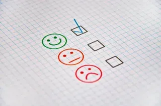 A paper displaying a check mark and multiple smiley faces, representing a theme of positivity and active involvement.