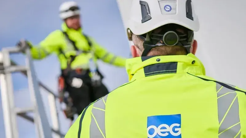 Two wind turbine technicians on turbine stairwell.
