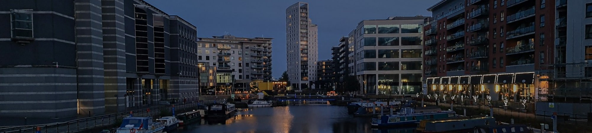 Lee Sweeney, Executive Director standing in front of our word wall in the Leeds office.