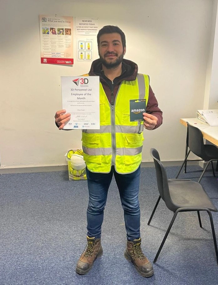 Olcay with his award and voucher at the site office