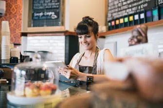 een vrouw in de bediening bij een koffietent