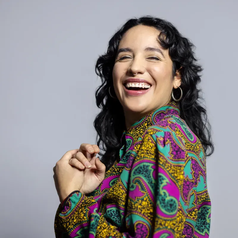 Woman smiling and clasping her hands together