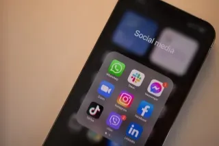 A smartphone displaying various social media apps on its screen, showcasing connectivity and digital interaction.