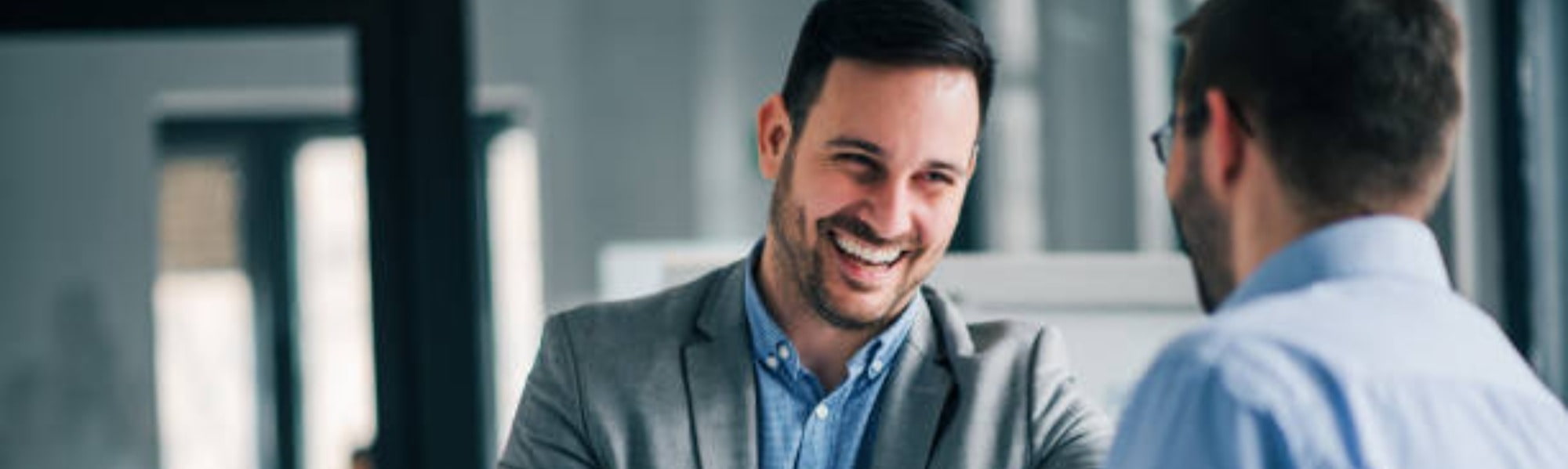 Image of two people smiling in a business meeting