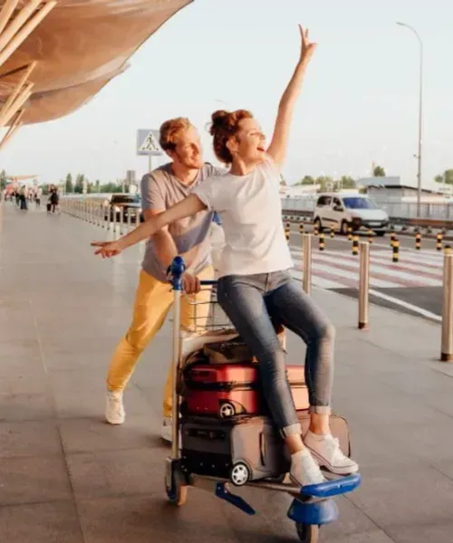 Man and Woman ready to start their journey together. The woman is sitting on the car with the luggage