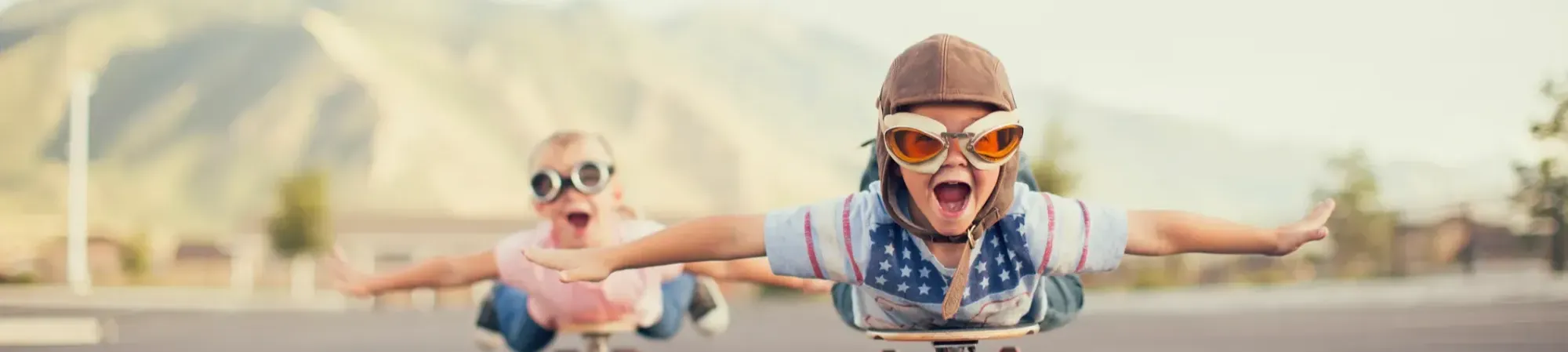 -	: kinderen die doen alsof ze vliegen op een skateboard, met een piloten muts en bril