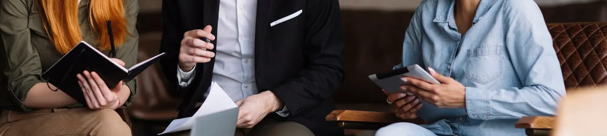 a business meeting with a smiling woman standing up presenting to colleagues