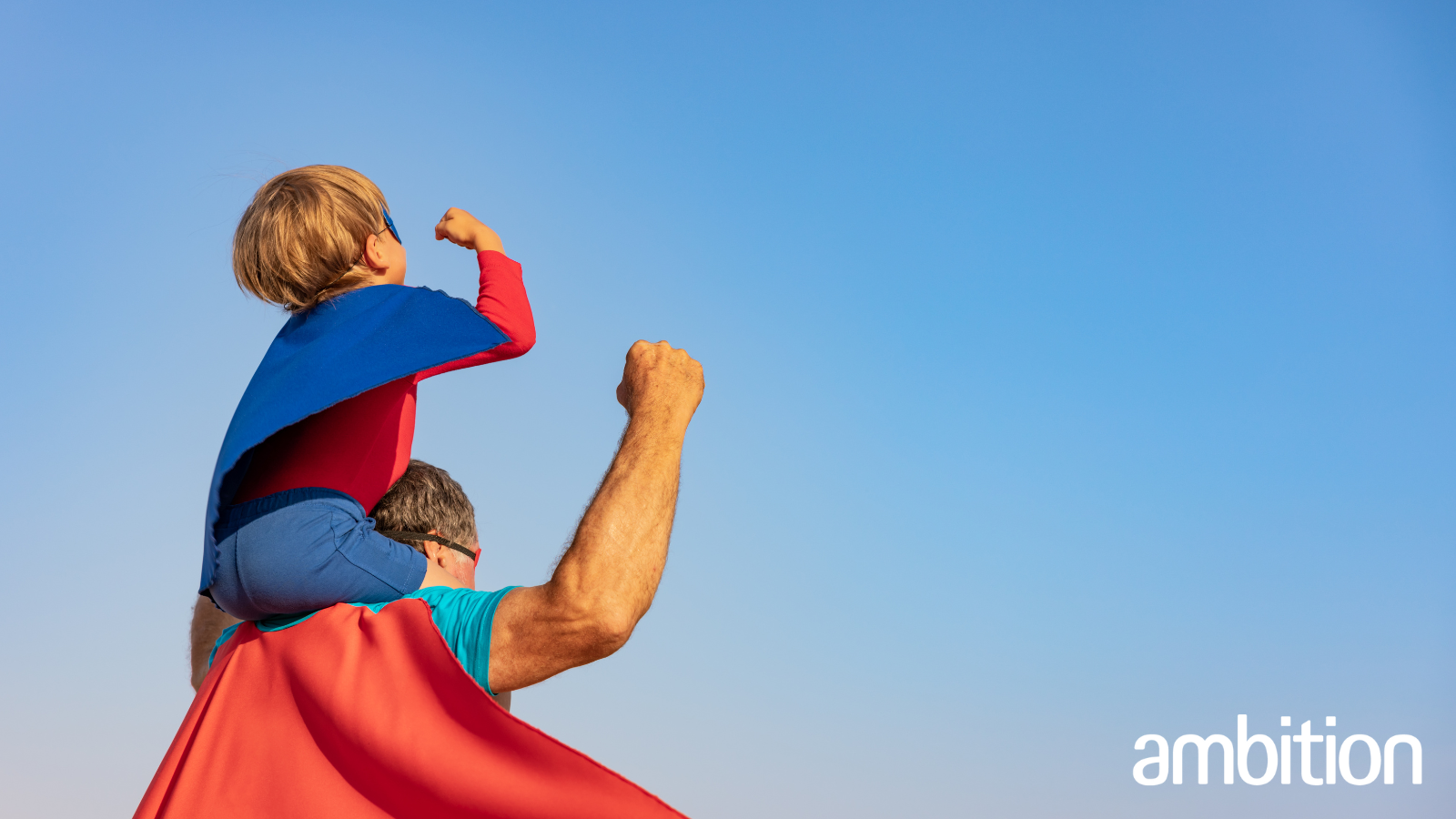 Father and son fist bumping the air wearing superhero outfits; international men's day; men's mental health