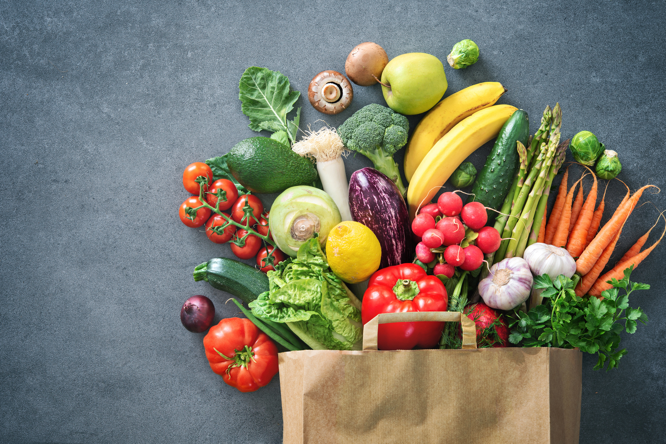 A mix of fresh produce items in a paper bag.