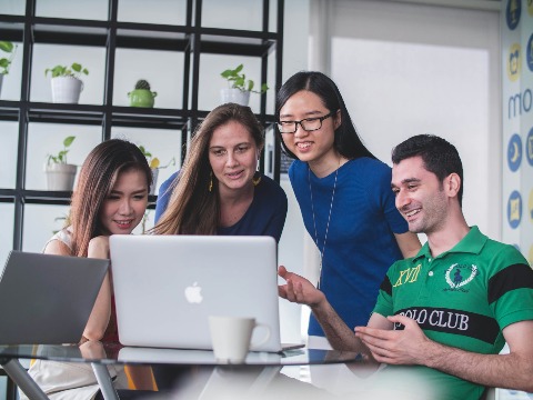 Staff looking over work on a laptop together