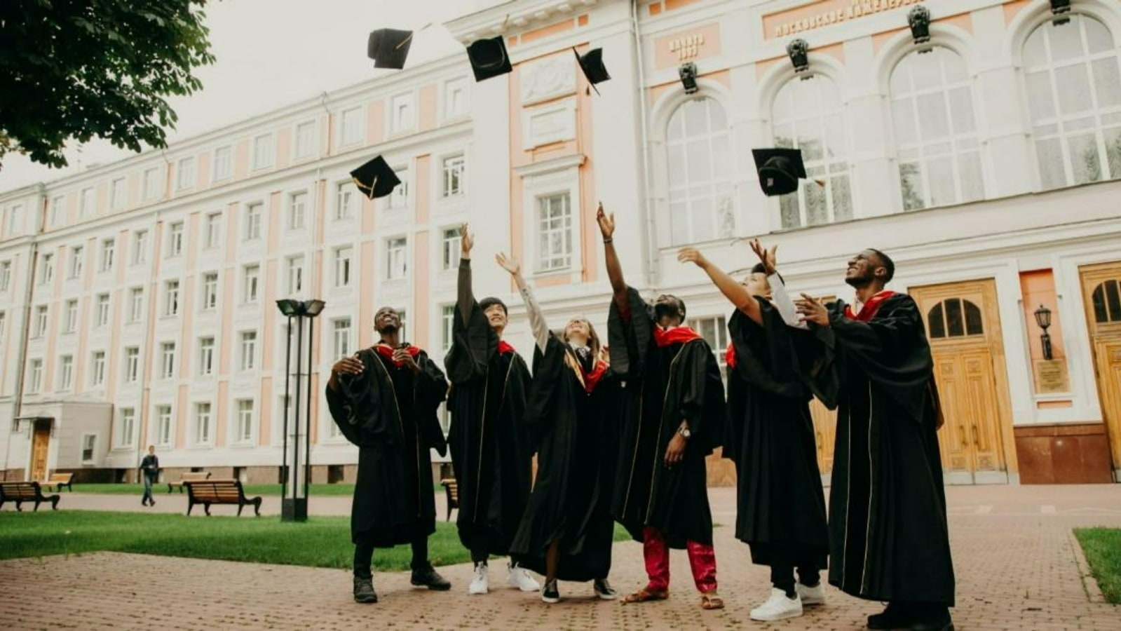 a group of graduates throwing their graduation cap in the air