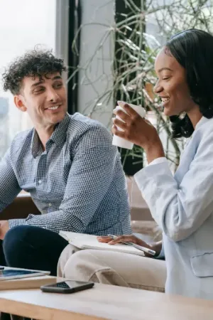  A man and woman engaged in conversation while seated at a table in a cozy coffee shop.