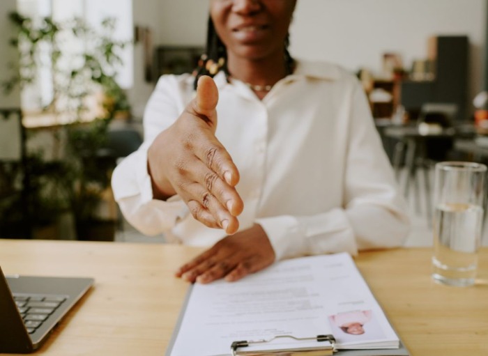 woman holding out hand in a handshake for a job interview