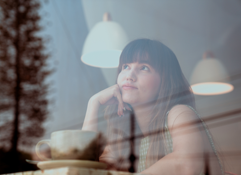 young woman with brown hair looking out of the window